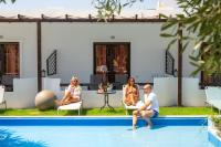 a group of people sitting around a pool at Skiathos Holiday Resort in Skiathos