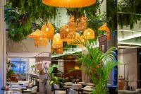 a restaurant with tables and chairs and chandeliers at Tri Hotel Premium Itapema in Itapema