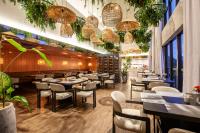 a restaurant with tables and chairs and plants at Tri Hotel Premium Itapema in Itapema