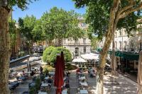 a street with tables and umbrellas in a city at Bali Dream II Hyper Centre Fontaine Moussue in Salon-de-Provence