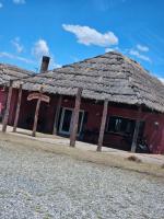 un edificio rosso con tetto di paglia di CountryHome Tierra Alta a Villa San Nicolás