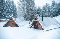 two huts covered in snow with trees in the background at Altipik - Lodges Insolites in Mont-Saxonnex