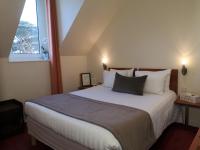 a bedroom with a large bed with two pillows at Hôtel Aux Tamaris - Vue Mer in Roscoff