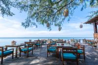 um restaurante na praia com mesas e cadeiras em Camia Resort & Spa em Duong Dong