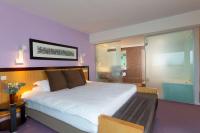 a bedroom with a large bed and a bathroom at Hotel Lille Euralille - Hilton Affiliate Hotel in Lille