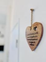 a wooden heart hanging on a door at Chaleureux T2 proche gare in Bourgoin