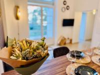 a bowl of flowers sitting on a wooden table at Chaleureux T2 proche gare in Bourgoin