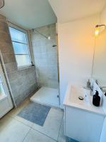 a white bathroom with a sink and a shower at Chaleureux T2 proche gare in Bourgoin