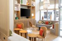a waiting room with chairs and a couch and a tv at Residence Inn by Marriott Paris Didot Montparnasse in Paris