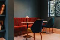 ein rotes Sofa mit zwei Stühlen und einem Tisch in der Unterkunft Casa Altata Hotel Boutique in Mexiko-Stadt