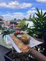 a person holding a plate of food on a balcony at Appartement gare Plaisir grignon in Plaisir