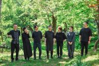 un grupo de personas de pie en la hierba en Shiroyamakan, en Shirakawa