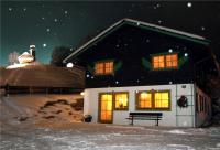 a house with a bench in front of it in the snow at Alpen Chalet ELLMAU Zentrum in Ellmau