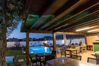 Un patio con mesas y sillas y una piscina. en JULİETOTEL, en Alacati