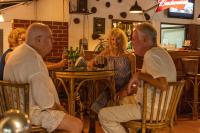 een groep mensen die aan een tafel in een restaurant zitten bij La Ben Resort in Colva