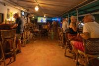 een groep mensen die aan een bar in een restaurant zitten bij La Ben Resort in Colva