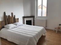 a white bedroom with a large bed and a fireplace at Maison de vacances in Châtelaillon-Plage