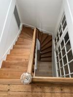 a cat laying on the floor next to a wooden staircase at Maison de vacances in Châtelaillon-Plage