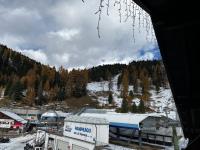 un grande edificio con una montagna innevata sullo sfondo di Ski Lodge Pampeago a Tesero
