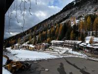 una montagna innevata con un edificio e un bulldozer di Ski Lodge Pampeago a Tesero