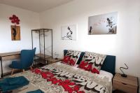 a bedroom with a bed with a blue chair and a desk at Appartement 6-8 personnes - Calme - Neuf - 15 min de Paris in Groslay