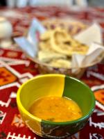 a yellow bowl of soup next to a bowl of food at Camp Dunes Insolites Sabria in Sabria