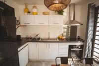 a kitchen with white cabinets and a sink at KozyKaz, notre villa cocooning avec piscine in Saint-Pierre