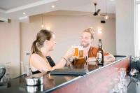 Een man en een vrouw drinken bier in een bar. bij Emerald Bay Resort Mirissa in Mirissa