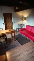 a living room with a red couch and a table at Pension Müllers Mühle in Großenhain