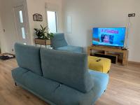 a living room with a blue couch and a television at Superbe Appartement atypique in Bouleternère