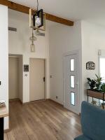 an empty living room with a blue couch and a door at Superbe Appartement atypique in Bouleternère