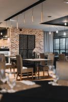 a dining room with tables and chairs and a brick wall at Dwór Kolesin in Nowe Kramsko