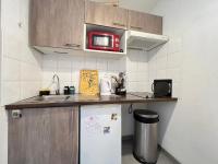 a small kitchen with a microwave and a refrigerator at Mon Cocon Occitan - 2p - Wifi &amp; Parking in Colomiers