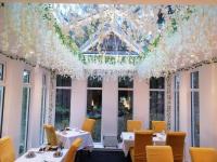 un comedor con mesas y sillas y un techo con flores en Guestling Hall Hotel, en Guestling