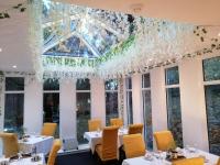 Un comedor con mesas y sillas y una lámpara de araña. en Guestling Hall Hotel, en Guestling