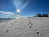 einen Strand mit Fußabdrücken im Sand und in der Sonne in der Unterkunft Deeded Beach Access- 10 min Walk to Hangout in Gulf Shores