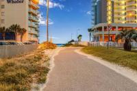 eine unbefestigte Straße neben einem Gebäude und dem Meer in der Unterkunft Deeded Beach Access- 10 min Walk to Hangout in Gulf Shores