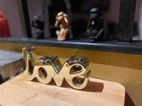a metal letter m on a table with monkeys on a shelf at HomeSparadise Loveroom in Besançon