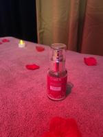a candle sitting on a table with red rose petals at HomeSparadise Loveroom in Besançon