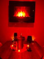 a red room with a fireplace and a table with candles at HomeSparadise Loveroom in Besançon