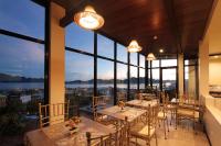 a restaurant with tables and chairs and large windows at GHIELLANIQA INN in San Nicolas