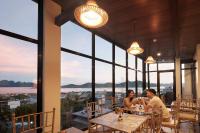two people sitting at tables in a restaurant with a view at GHIELLANIQA INN in San Nicolas