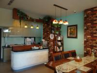 a kitchen with a counter and two tables and a kitchen with a counter at Bestime B&amp;B in Jiji