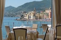 a restaurant with a view of the ocean and buildings at Hotel Cenobio Dei Dogi in Camogli