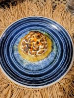 un piatto blu con una pizza sul tavolo di La maison d'hôte de la Forêt Retrouvée a Mahajanga