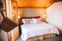 a bedroom with a bed with white sheets and pillows at Pousada Aberdeen in Campos do Jordão