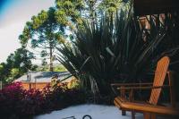 a wooden chair sitting next to a bunch of plants at Pousada Aberdeen in Campos do Jordão