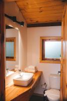 a bathroom with a sink and a toilet and a mirror at Pousada Aberdeen in Campos do Jordão