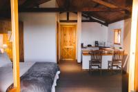a bedroom with a bed and a kitchen with a table at Pousada Aberdeen in Campos do Jordão