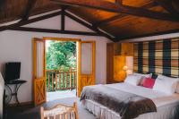 a bedroom with a bed and a large window at Pousada Aberdeen in Campos do Jordão